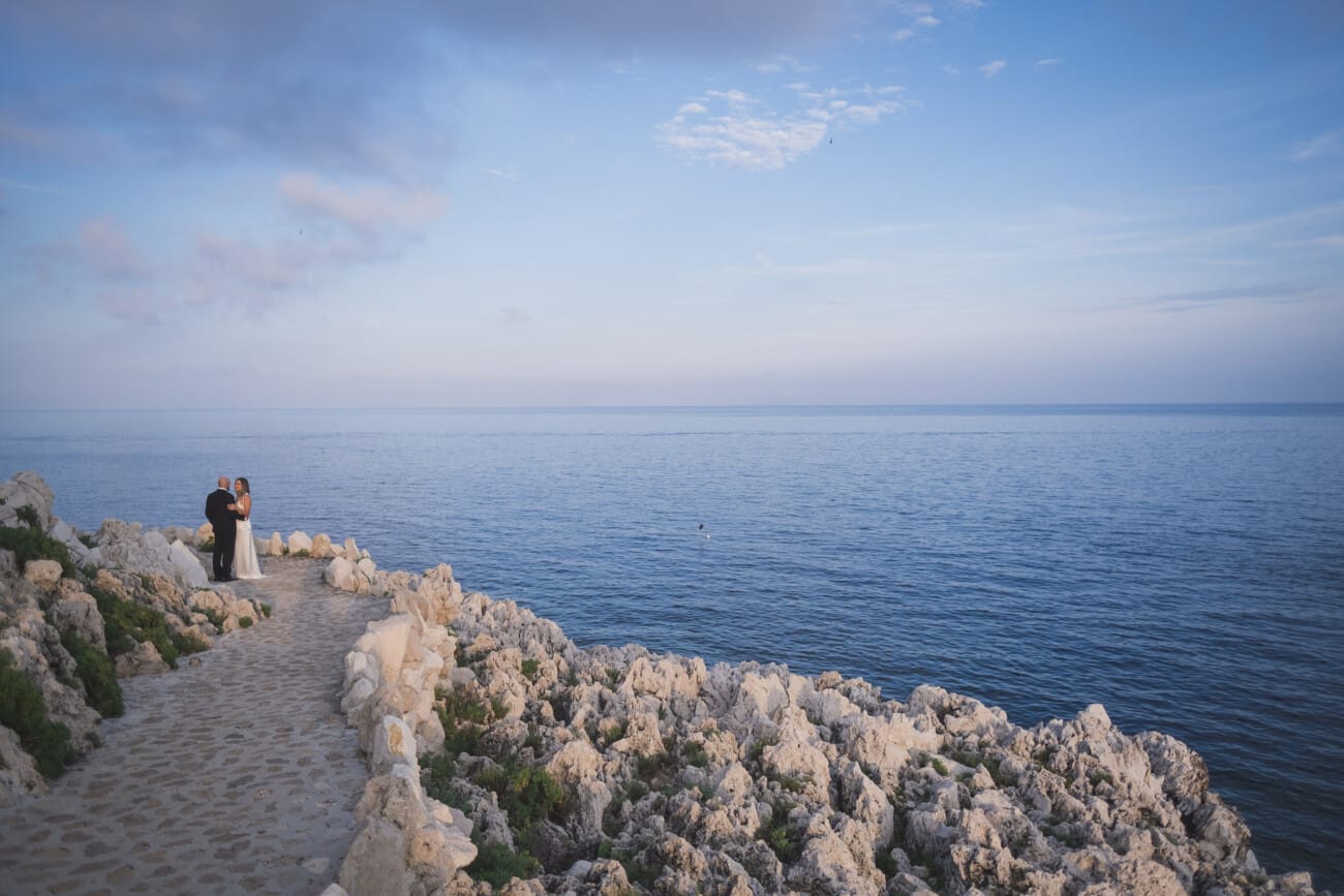 couple walking coastal path during golden hour French Riviera elopement
