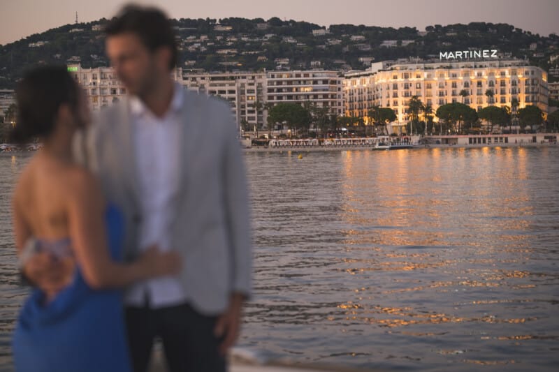 Couple celebrating their engagement, with Cannes Hotels in the backdrop after their Yacht Proposal in Bay of Cannes