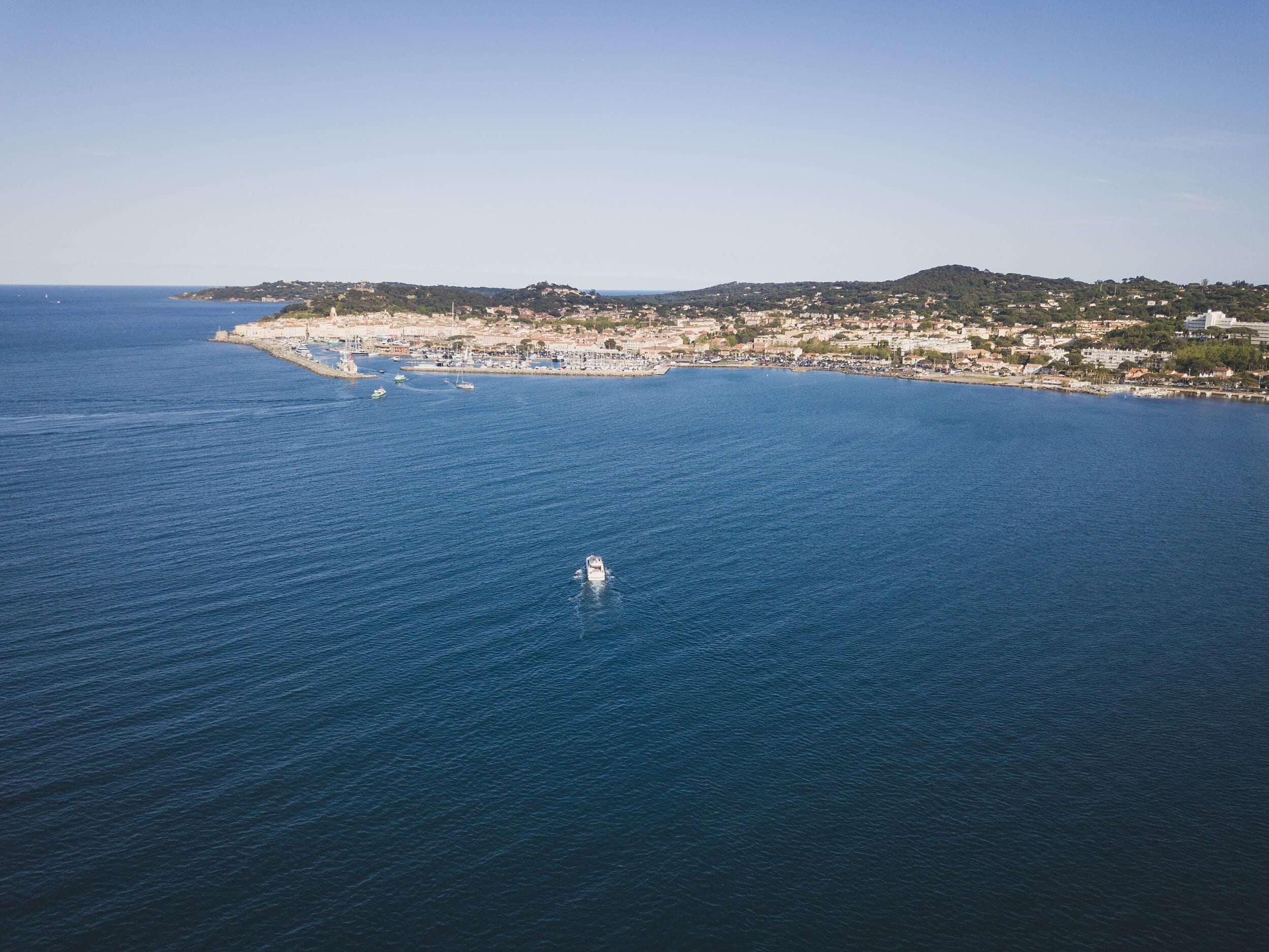 A yacht arriving at Saint-Tropez port to pick up the couple and bring them to a quiet bay for their proposal