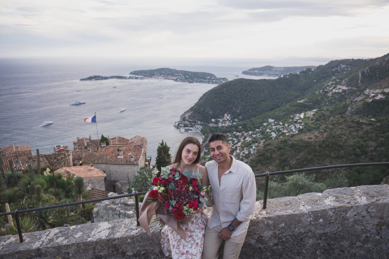 Wide angle shot showcasing the "crazy view" from the top of Eze village with the couple in the frame.